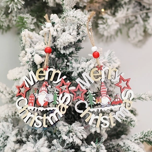 Rustic wooden Merry Christmas gnome ornaments hanging on a snowy tree branch