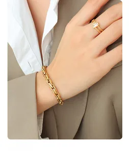 Detailed view of chunky 18k gold plated chain bracelet and square zircon ring set