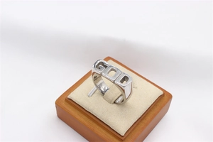 Detailed close-up of a silver GOD lettering men's ring on a wooden display stand