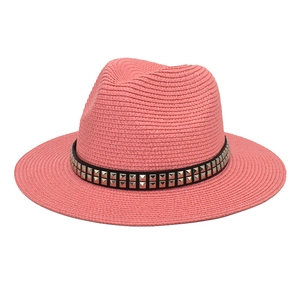 Detail of coral pink straw fedora hat featuring a black band with silver square studs