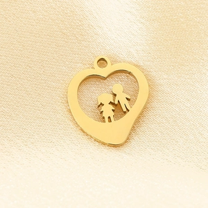 Detailed view of a gold heart pendant with silhouettes of two children on silk fabric