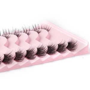 Close-up of natural black half-eyelashes with clear bands on a pink display tray