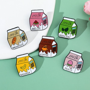 Detailed view of six colorful enamel milk box pins on a plate with various fruit labels