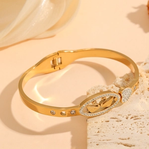 Golden titanium steel bangle featuring a double swan motif and heart-shaped crystals