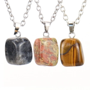 Macro detail of natural Tiger's Eye and Unakite stone pendants on silver necklaces