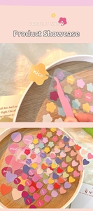 Detail of colorful PET stickers in flower and heart shapes with pink tweezers
