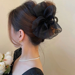 Detail of elegant black mesh bow hair claw clip worn on hair with a soft chiffon finish