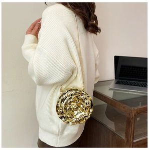 Detailed view of a gold rose-shaped hard shell evening clutch bag with metal chain