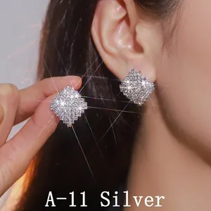 Detailed close-up of geometric diamond earrings worn by a model in silver finish