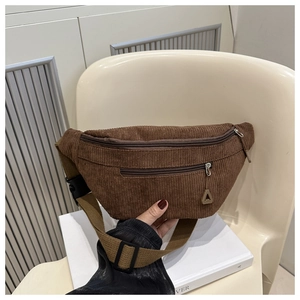 Close-up of brown corduroy waist bag with dual zippers and adjustable black strap