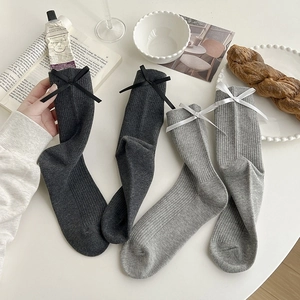 Detail of grey cotton ribbed socks with elegant bow knots for a preppy school style