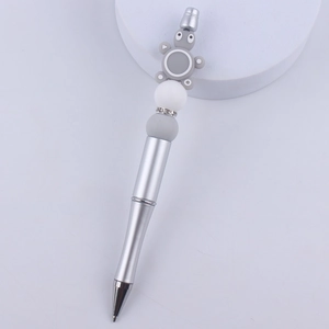 Detail of silver beaded pen featuring a grey cartoon koala and sparkling rhinestone rings