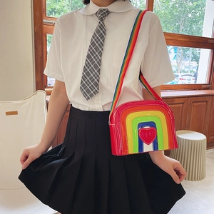 Close-up of rainbow heart crossbody bag with glossy finish and colorful textile strap