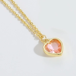 Macro view of polished pink heart gemstone pendant and gold chain necklace craftsmanship