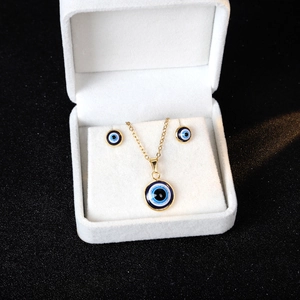 Detail of evil eye jewelry set with necklace and earrings in a luxury white gift box