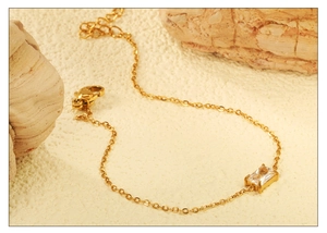 Detail of gold chain bracelet featuring a rectangular zircon and lobster clasp closure