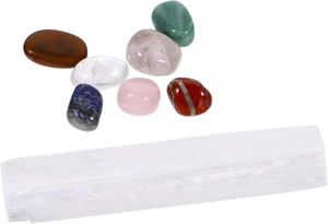 Dettaglio di pietre naturali burattate assortite con una bacchetta di selenite bianca