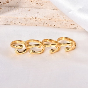 Set of four gold-plated hug rings with unique open adjustable hands design on silk background