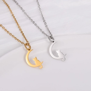 Close-up of gold and silver stainless steel moon and cat pendant necklaces on chain