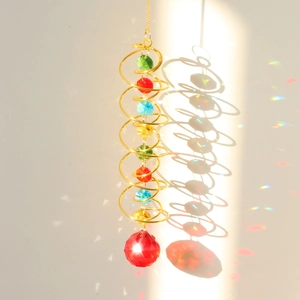 Detail of golden spiral wind chime with colorful crystal beads and a large red crystal ball