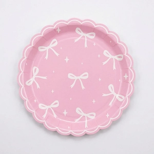 Pink bow party paper plate with scalloped edges for birthday and festive celebrations