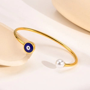 Minimalist gold open bangle with blue evil eye enamel and white pearl detail