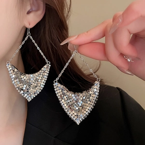 Detailed close-up of a silver mesh triangle tassel earring worn by a female model