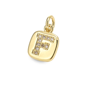 Detailed macro shot of a golden square letter F pendant with inlaid clear zircon stones