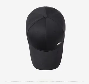 Top view of a black baseball cap with a circular silver metal badge and six-panel design