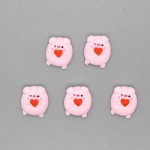 Detailed close-up of five cute pink resin pig charms with red hearts for DIY jewelry making