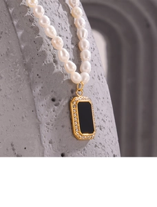 Detail of pearl necklace featuring a gold-edged black enamel pendant with zircon inlay