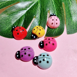 Close-up of colorful resin ladybug charms for DIY hair clips and phone case decor