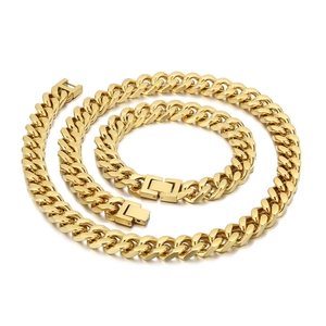 Golden Cuban link necklace and bracelet set with flat metal chains on white background