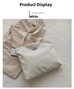 Detail view of white corduroy tote bag with textured stripes and minimalist cloth label