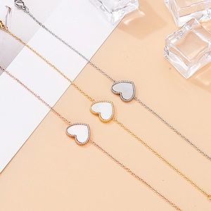 Drei Herz-Armbänder in Silber, Gold und Roségold auf kreativem Eis-Hintergrund
