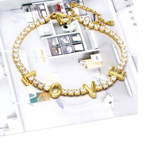 Detail of gold LOVE tennis bracelet with sparkling zircons and adjustable clasp chain