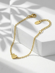 Detailed close-up of 18k gold plated heart charm bracelet with K18 hallmark on the tag