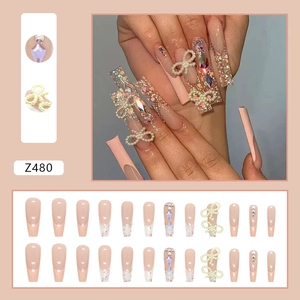 Sparkly French press-on nails with rhinestones and pearl bows, nude pink glitter set