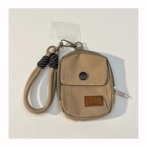 Macro shot of khaki canvas mini backpack coin purse with durable matching thick lanyard