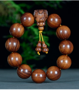 Détail des perles bouddhistes en bois de rose jaune avec breloque PiXiu et pendentifs gourde