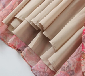 Detail of pink floral print dress hem featuring lightweight fabric and beige inner lining
