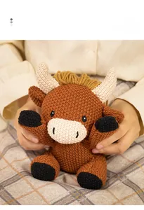 Detailed texture of a handmade crochet bull doll held in hands with a warm cozy vibe
