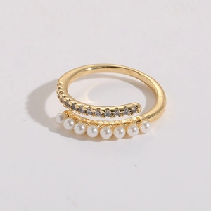 Detail showing freshwater pearl and cubic zirconia inlays on a gold open ring