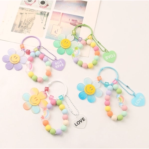 Close-up of candy-colored beaded keychains with glittery flower and heart resin charms