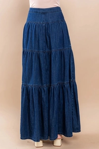 Dettaglio della gonna lunga in denim con balze a strati e trama del tessuto blu scuro