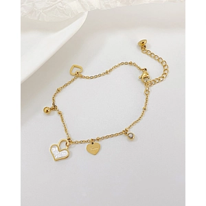Macro view of gold stainless steel bracelet with heart charms and lobster clasp detail