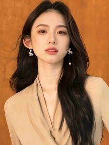 Detail of elegant gold-plated horse earrings with shimmering pearls on a model