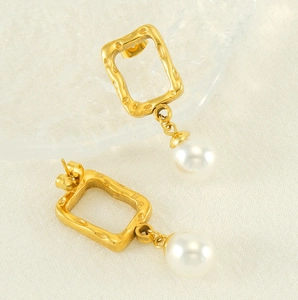 Detail of vintage gold textured hollow square earrings with elegant white drop pearls