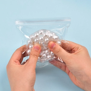 Detail of colorful squishy stress balls in clear packaging held by hands