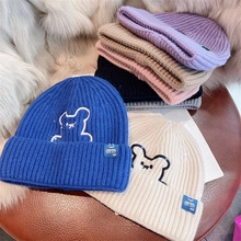Thick knit beanies with embroidered bear labels in various colors for winter warmth